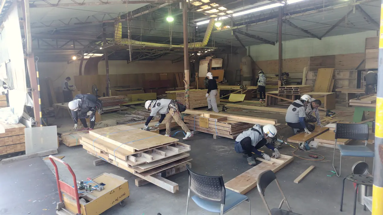 馬見塚建設の型枠職人チーム — 倉庫での作業風景